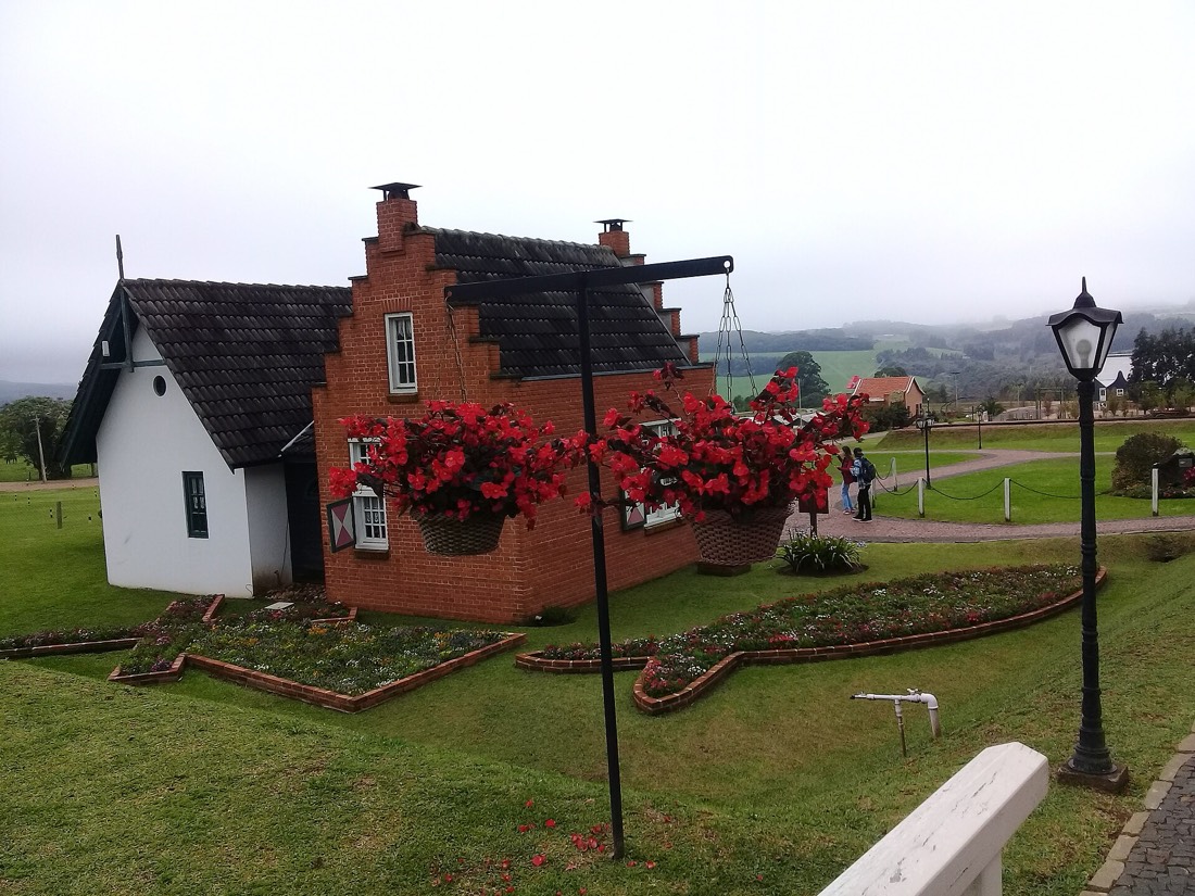 Casa de tijolo holandesa com flores vermelhas