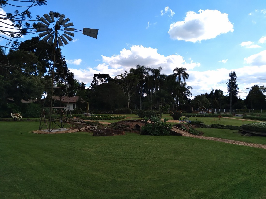 Jardins do parque com cata-vento e ponte